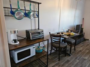 a small kitchen with a table with a microwave and a table with a microwave at Parc Octopus in Desbiens