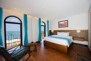 a bedroom with a bed and a view of the ocean at Fella Hotel Phu Quoc - Free Hon Thom Island Waterpark Cable Car in Phu Quoc