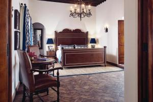 ein Schlafzimmer mit einem Bett, einem Tisch und einem Stuhl in der Unterkunft Casa de Sierra Nevada, A Belmond Hotel, San Miguel de Allende in San Miguel de Allende