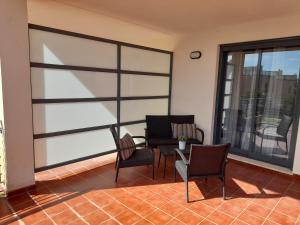 uma sala de estar com cadeiras e uma mesa na varanda em Piso de lujo - descansar y trabajar en Golf Panoramica para 4 pers - internet fibra GRATIS em Sant Jordi