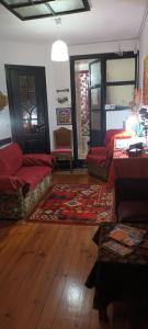 a living room with red couches and a wooden floor at Alojamento centro do Porto -Almada in Porto