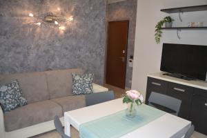 a living room with a couch and a tv at Appartamento Il Volo in Lippo di Calderara di Reno
