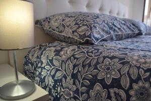 a bed with a blue and white blanket and pillows at Appartamento Il Volo in Lippo di Calderara di Reno