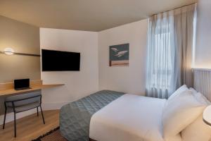 Pokój hotelowy z łóżkiem i biurkiem w obiekcie Metropolitan Hotel w Tel Awiwie