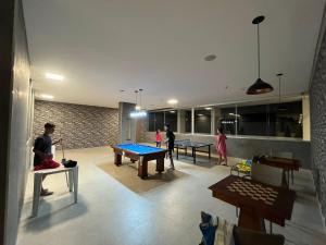 a group of people playing ping pong in a room at Recanto do Bosque FLAT 205 in Caldas Novas