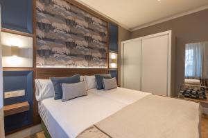 um quarto com uma cama grande e paredes azuis em BiBo Suites Palacio de Portago em Granada