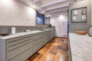 una grande cucina con armadi grigi e una finestra di Le Contemporain - Chalet vue sur le Mont Blanc a Saint-Gervais-les-Bains
