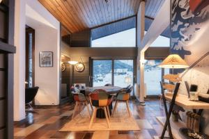 una sala da pranzo con tavolo e sedie di Le Contemporain - Chalet vue sur le Mont Blanc a Saint-Gervais-les-Bains