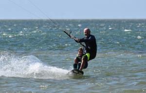 Ein Mann auf einem Surfbrett im Wasser in der Unterkunft Secret Spot Dakhla in Ad-Dakhla