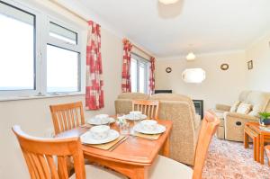 a dining room and living room with a table and chairs at 2 Brambles Farm Holiday Bungalow in Freshwater