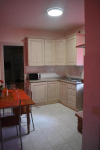 cocina con armarios blancos, mesa y comedor en Il pensiero, en Orvieto