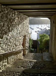 eine Gasse mit einem Steingebäude und Booten im Wasser in der Unterkunft 4 Bedroom Cottage with panoramic Harbour views in Falmouth