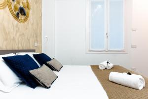 ein Bett mit blauen und weißen Kissen und einem Fenster in der Unterkunft Un Nido Sull'Arena - Royal Welcome in Verona