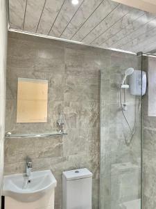 a bathroom with a shower and a toilet and a sink at Huge New Apartment Great For Locum and Contractors in Leeds
