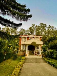 una casa con una entrada delante de ella en Narmada Holiday Home, en Ooty