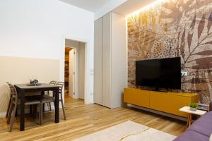 ein Wohnzimmer mit einem Tisch und einem TV an der Wand in der Unterkunft Un Nido Sull'Arena - Royal Welcome in Verona
