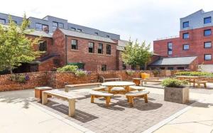 a group of picnic tables and benches in a courtyard at Cosy Modern Studios at Sheffield 3 located near the University of Sheffield in Sheffield