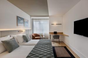 a hotel room with a bed and a tv at Metropolitan Hotel in Tel Aviv