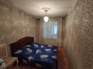 a bedroom with a bed with a blue comforter at Квартиры посуточно и помесячно в городе Гюмри, Армения in Gyumri