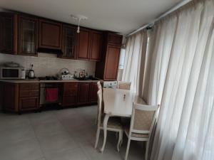 a kitchen with wooden cabinets and a table and chairs at Квартиры посуточно и помесячно в городе Гюмри, Армения in Gyumri