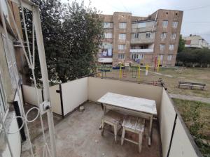 a table and chairs on a balcony with a playground at Квартиры посуточно и помесячно в городе Гюмри, Армения in Gyumri