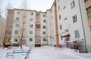 un patio nevado frente a un edificio en 2 комнатная квартира, по суточно, напротив ТД Сырымбет, en Kokshetau