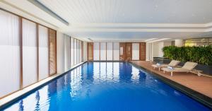 a large swimming pool in a building with windows at The Residency Towers Puducherry in Pondicherry