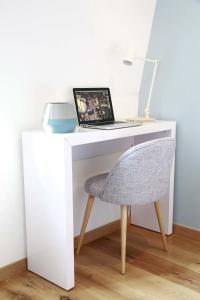 - un bureau blanc avec un ordinateur portable et une chaise dans l'établissement Flandres Appart' Hotel par NOCNOC, à Lille