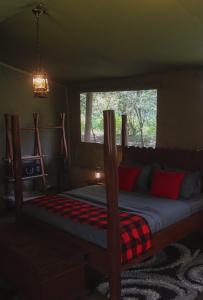 ein Schlafzimmer mit einem Bett in einem Zimmer mit einem Fenster in der Unterkunft Drunken Elephant Mara in Sekenani