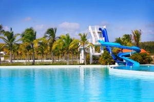 - un toboggan bleu dans une piscine avec un complexe dans l'établissement Playa Blanca Town Center B, à Río Hato