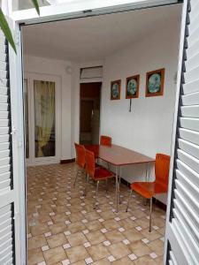 a dining room with a table and orange chairs at Apartment Pamela in Gajac +9 photos
