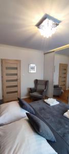 1 dormitorio con 1 cama, 1 silla y 1 lámpara de araña en Gold Apartments Penthouse en Rzeszów