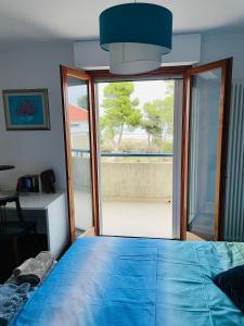 ein Schlafzimmer mit einem blauen Bett und einem großen Fenster in der Unterkunft Attico Vista e Fronte mare ZaffiroBlu con posto auto in Montesilvano