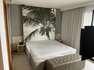 a bedroom with a bed with a palm tree mural at Quarto 50m2 próximo shopping Salvador in Salvador