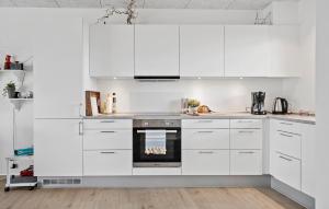 uma cozinha branca com armários brancos e um forno em Amazing Apartment In Ringkbing With Wifi em Ringkøbing