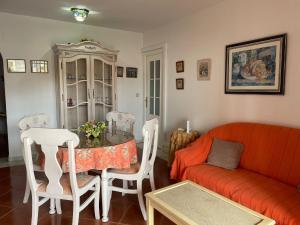sala de estar con sofá rojo y mesa en PRECIOSO APARTAMENTO VISTAS LATERALES AL MAR, en Isla Canela