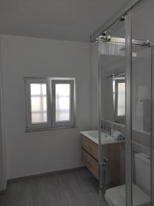 a bathroom with a glass shower and a sink at Apartamento Area Pequena Ézaro 2 in Ézaro