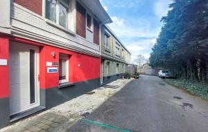 a red building with a car parked next to a street at 3 Bedroom Lovely Home In Dunkerque in Dunkerque