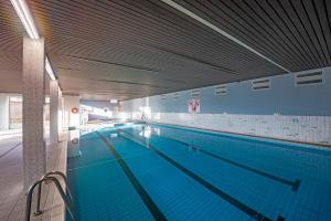 a large swimming pool in a large building at SilverSunSet De Haan in De Haan
