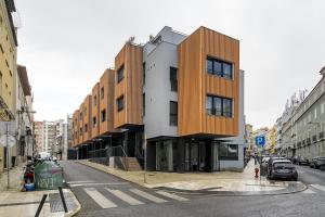 un bâtiment dans une rue de la ville avec des voitures garées dans l'établissement WHome Urban Oasis: Modern Living with Parking & AC, à Lisbonne