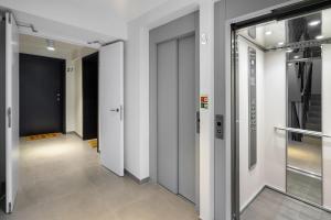 un couloir avec des murs blancs et des portes en verre dans l'établissement WHome Urban Oasis: Modern Living with Parking & AC, à Lisbonne