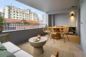 Cette chambre dispose d'un balcon avec une table et des chaises. dans l'établissement WHome Urban Oasis: Modern Living with Parking & AC, à Lisbonne