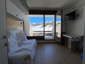 een slaapkamer met een bed en uitzicht op het strand bij Studio La Joue du Loup, 1 pièce, 4 personnes - FR-1-504-185 in Le Dévoluy