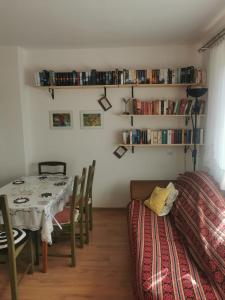 a dining room with a table and chairs and bookshelves at Biohof Am Turawa-See in Szczedrzyk