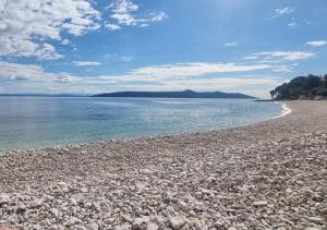 una spiaggia con rocce e acqua in una giornata di sole di Villa Visum Mare Tribus a Mošćenička Draga 1 altra foto