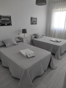 two beds with towels on them in a bedroom at Apartamento Area Pequena Ézaro 2 in Ézaro