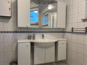 La salle de bains blanche est pourvue d'un lavabo et d'un miroir. dans l'établissement Gästehaus Brunswiek Erdgeschoss, à Vordorf