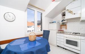 uma cozinha com uma mesa e um relógio na parede em 1 Bedroom Lovely Apartment In Dubrovnik em Dubrovnik