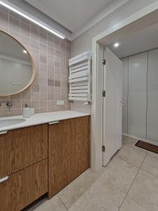 a bathroom with a sink and a mirror at New Funcional Easy Stay High Standard Kraków apartment free garage parking in Kraków
