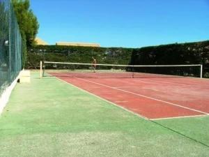 een persoon tennist op een tennisbaan bij Appartement Fleury-Saint-Pierre-la-Mer, 3 pièces, 5 personnes - FR-1-229D-268 in Fleury